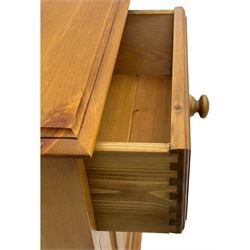 Pine chest of drawers topped with carved pediment with acorn and oak leaf motif, fitted with two short over three long drawers, standing on shaped apron base (W92, D46, H97cm); pine bedside cabinet, single drawer above paneled cupboard door enclosing open storage, shaped plinth base (W43, L32, H67cm)