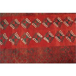 Afghan Turkoman crimson ground rug decorated with twin rows of hooked geometric guls within broad compartmented geometric borders (125cm x 201cm); Afghan Bokhara rug with repeated octagonal guls on a terracotta ground, enclosed by multiple geometric borders and patterned elem panels (120cm x 192cm) (2)