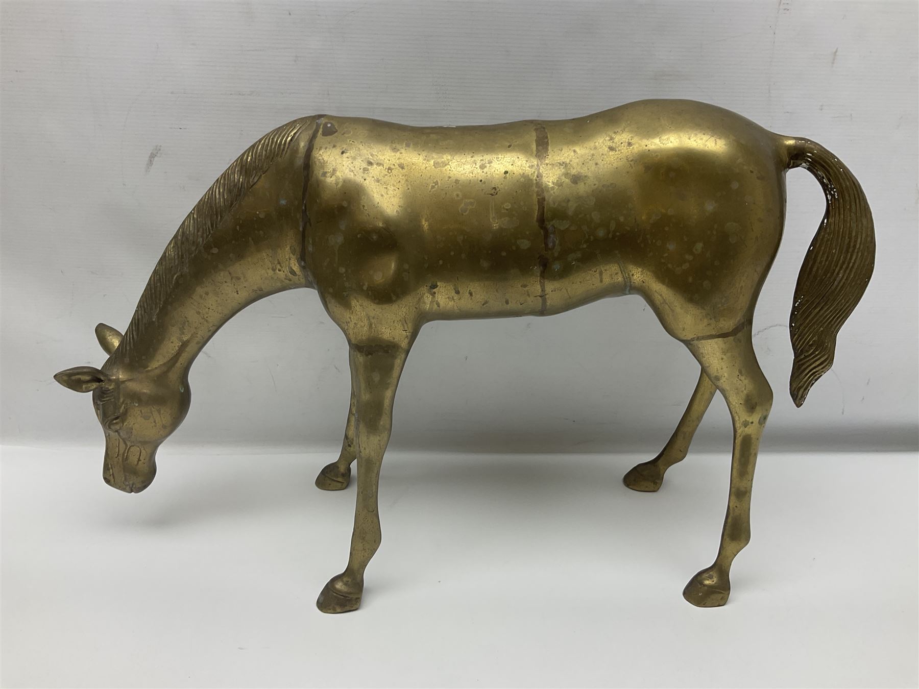 Pair of large brass horse figures, the first modelled as a standing horse, the second as a horse bending to graze, tallest H27cm