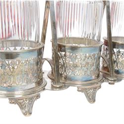 Late 19th century silver plated Silber & Fleming triple decanter stand, the three cut glass decanters with spire stoppers housed within foliate and scroll pierced bottle sleeves, upon a tripart base with six scroll feet, the base mounted with articulated x-frame curved handle, including handle when positioned upright H35.5cm, W34cm