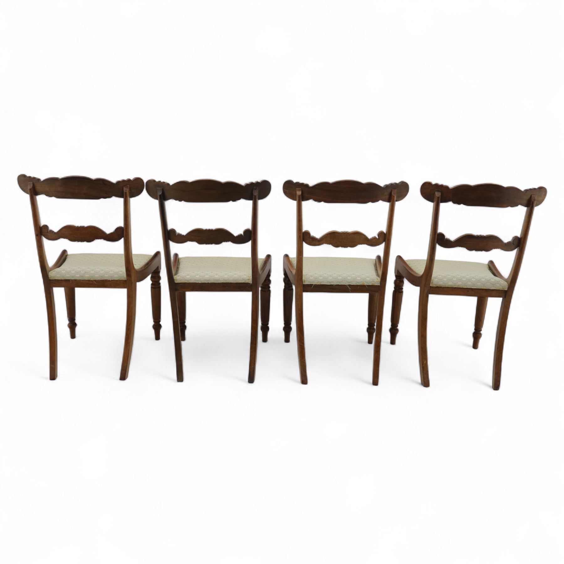 Set of four 19th-century rosewood dining chairs in the William IV style, shaped and carved top rail with fan and scroll decoration above a upholstered padded seat on reeded and turned front legs 