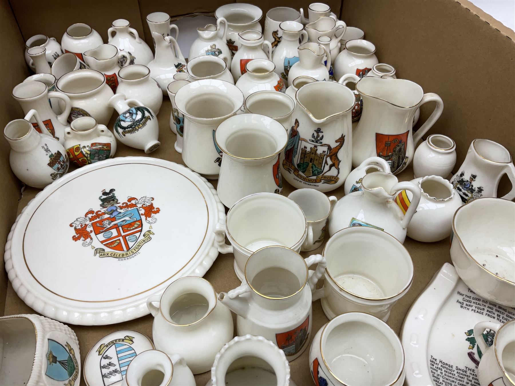 Collection of W H Goss crested ware, to include Yorkshire Roman Ewer, Scarborough ancient jug, salt and pepper shakers, Norwegian horse shaped beer bowl, The Old Horse Shoe, etc, together with five Shelley examples modelled as piano, boat, heart shaped box, etc, in two boxes 