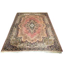 Large Persian design peach ground carpet, the field decorated with floral medallion, multi-band border decorated with repeating flower head pattern