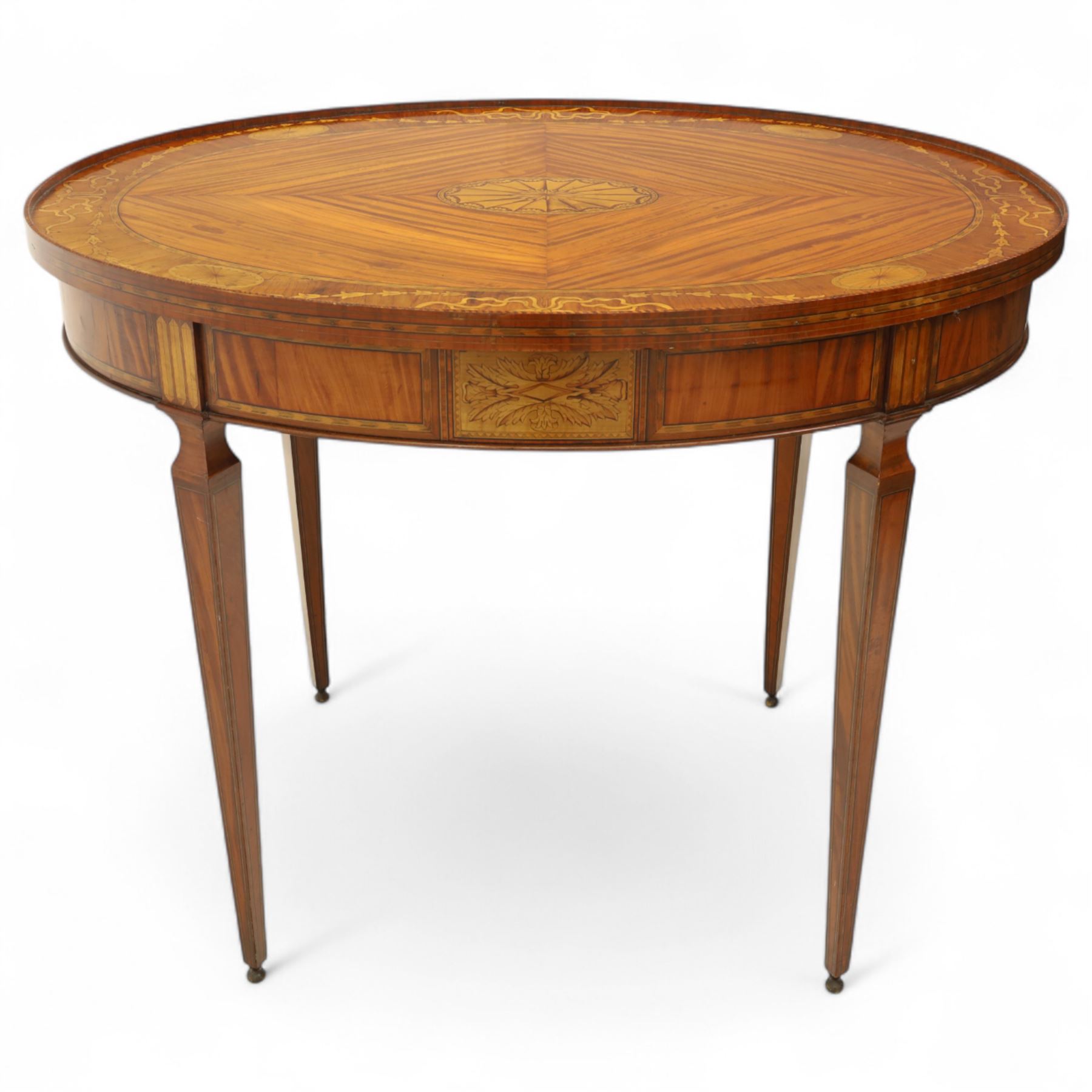 Aldam Heaton & Co (fl.1878-97) - late 19th century Sheraton revival style satinwood inlaid oval centre table, raised inlaid edge, centre with finely executed large central  inlaid medallion, surrounded by ribbon tied swags interspaced with medallions, frieze with rectangular symmetrical panels of foliate sprays of acanthus leaves, raised on four square section tapering legs with cavetti shaped shoulders with stringing on brass bulb feet, underside with bone plaque signed Aldam Heaton & Co, Baker St, London
