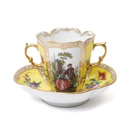 Two 19th century Dresden quatrefoil twin handled chocolate cups and saucers, decorated with Watteau style panels, with pink and yellow floral ground and gilt heightened decoration, blue 'AR' mark to underside for Helena Wolfsohn (2)