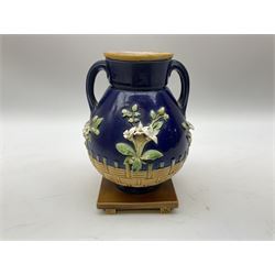 Minton majolica vase, the squat body with twin handles, with part osier moulding and applied Spring flowers against a cobalt blue ground, upon integral square base, impressed beneath Minton 1316, H16.5cm