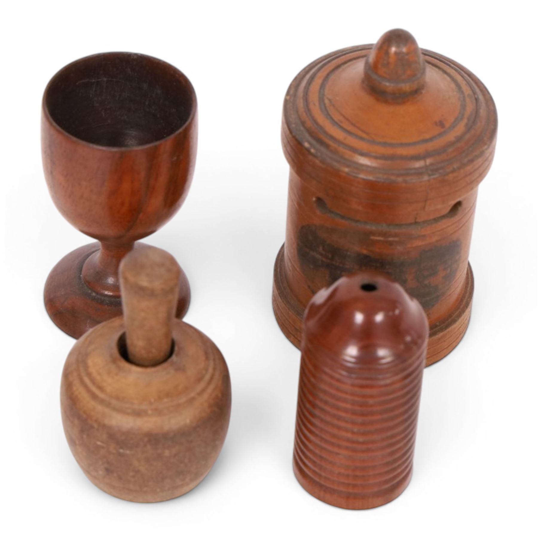 Group of treen, comprising, Mauchline ware coin box, box modelled as pear, egg cup, butter stamp, bell push, sewing implement, weaving tool, and box modelled as book