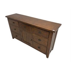 Stained pine rustic sideboard, rectangular top over seven drawers and single panelled cupboard, fitted with shell handles