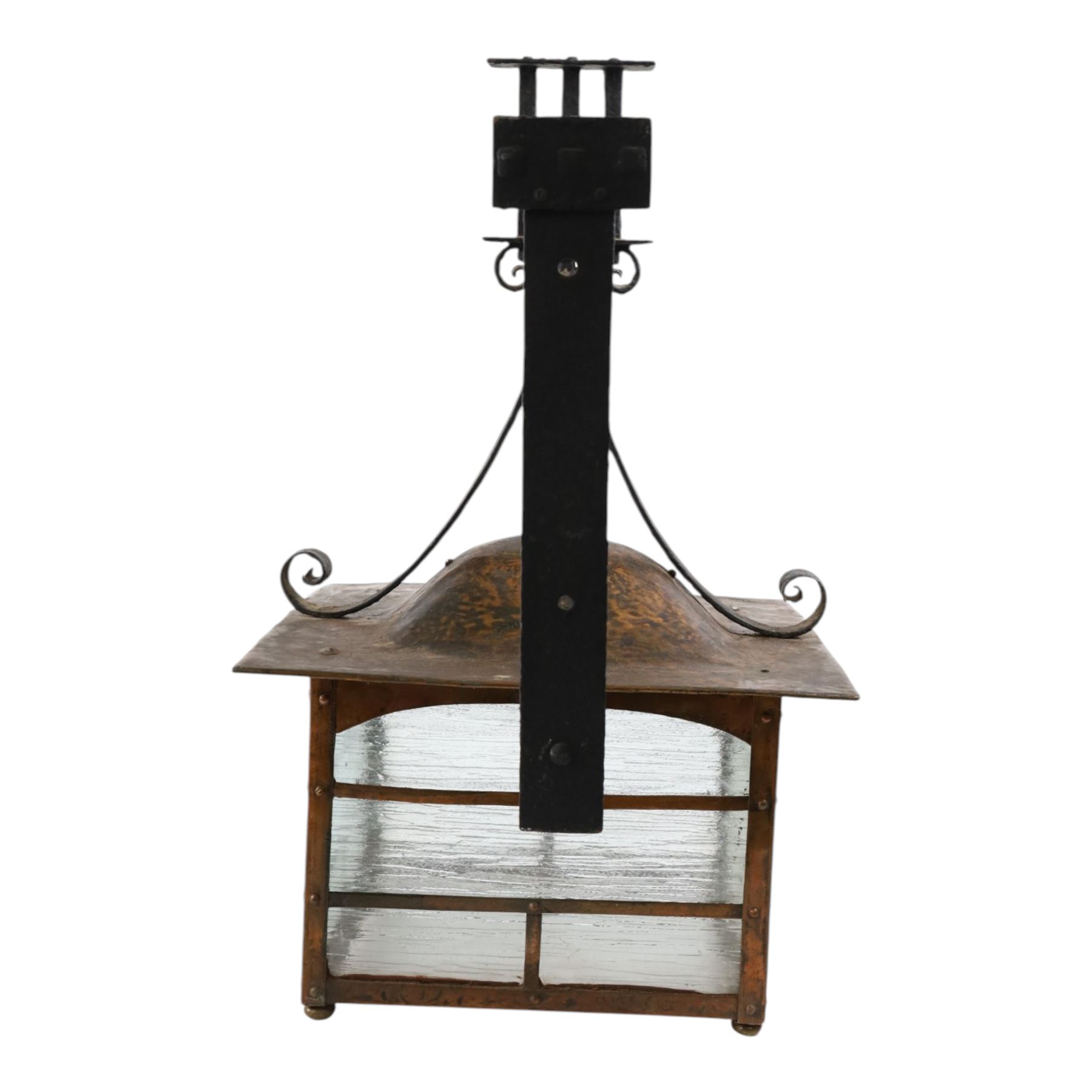 20th century, Arts and Crafts style copper porch lantern, of rectangular form, with cast iron scrolling wall fittings