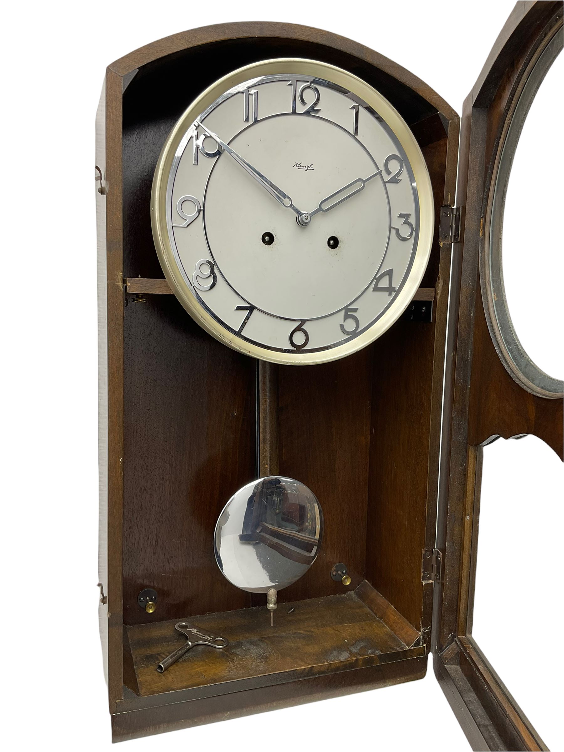 A mid 20th century German wall clock in a veneered mahogany case with a