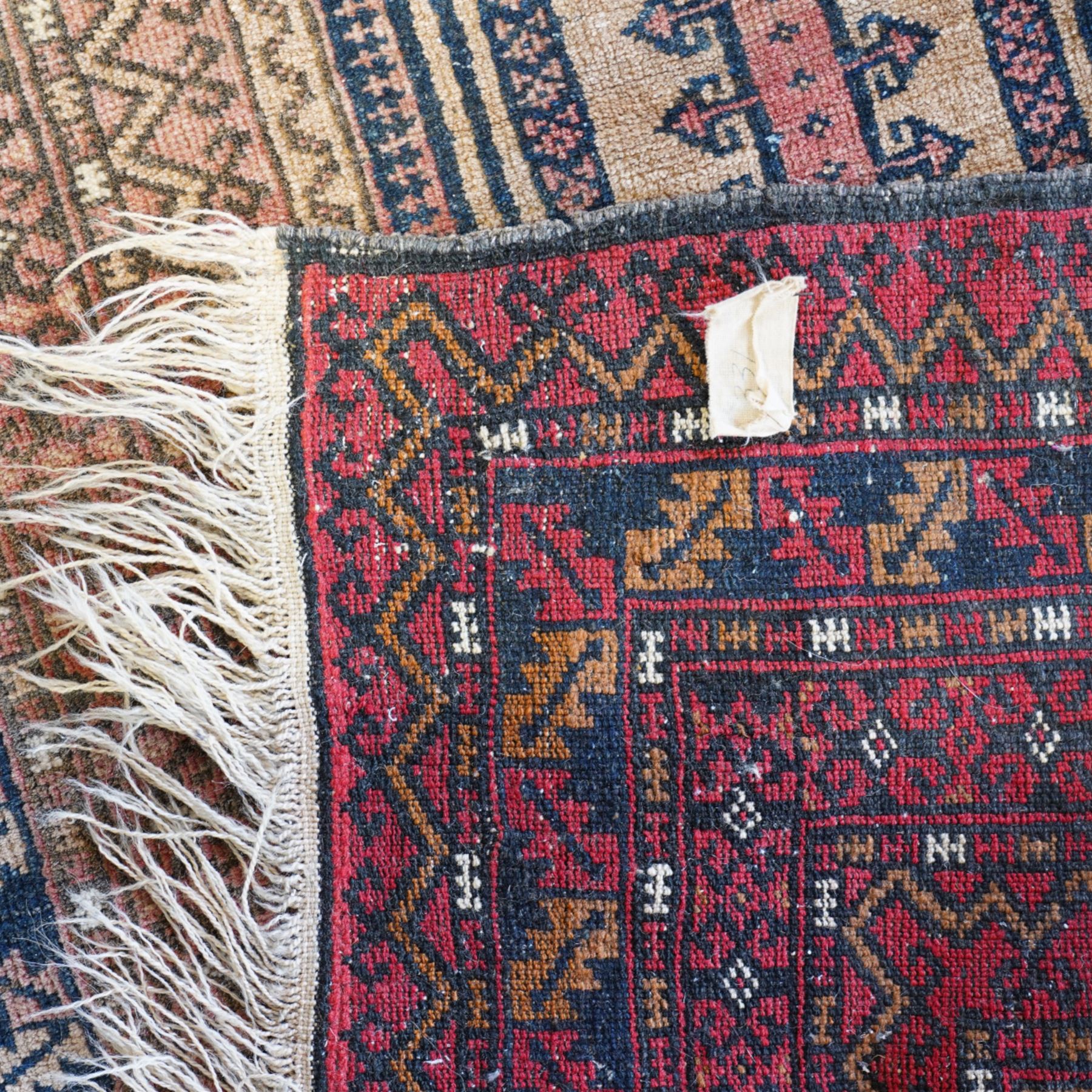 Persian Baluch style prayer rug,  hand-knotted wool rug, central mihrab design with geometric hooked motifs, corners with medallions, outlined in dark blue, with a stepped arch with hanging lamp motif at the top, main border on dark blue ground with alternating hooked and stepped motifs, guard borders with repeating diamond and chevron pattern 