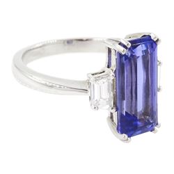 Platinum tanzanite and diamond three stone ring, single emerald cut tanzanite of approx 4.20 carat, with with a single trapeze cut diamond set either side, stamped PT950, total diamond weight approx 0.49 carat, with Alan Poultney Gems report