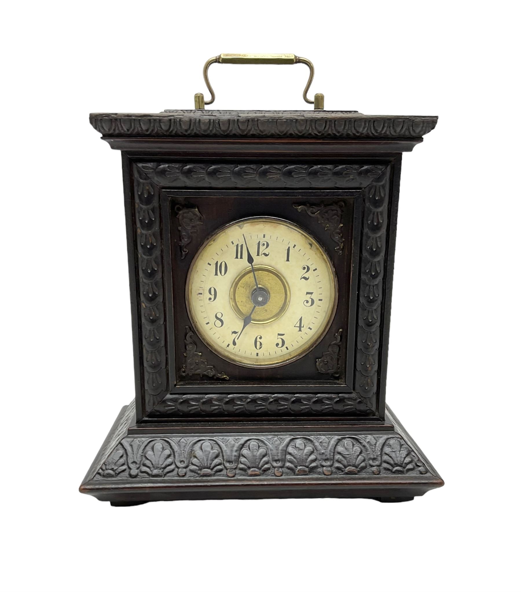 German - late 19th century  Black Forest Junghans alarm clock, profusely carved mouldings with glass side panels and carrying handle, two part dial with a gilt centre, Arabic numerals, minute track and steel spade hands, 30hr  balance wheel movement with alarm sounding on a bell, wound and set from the rear, with Key.