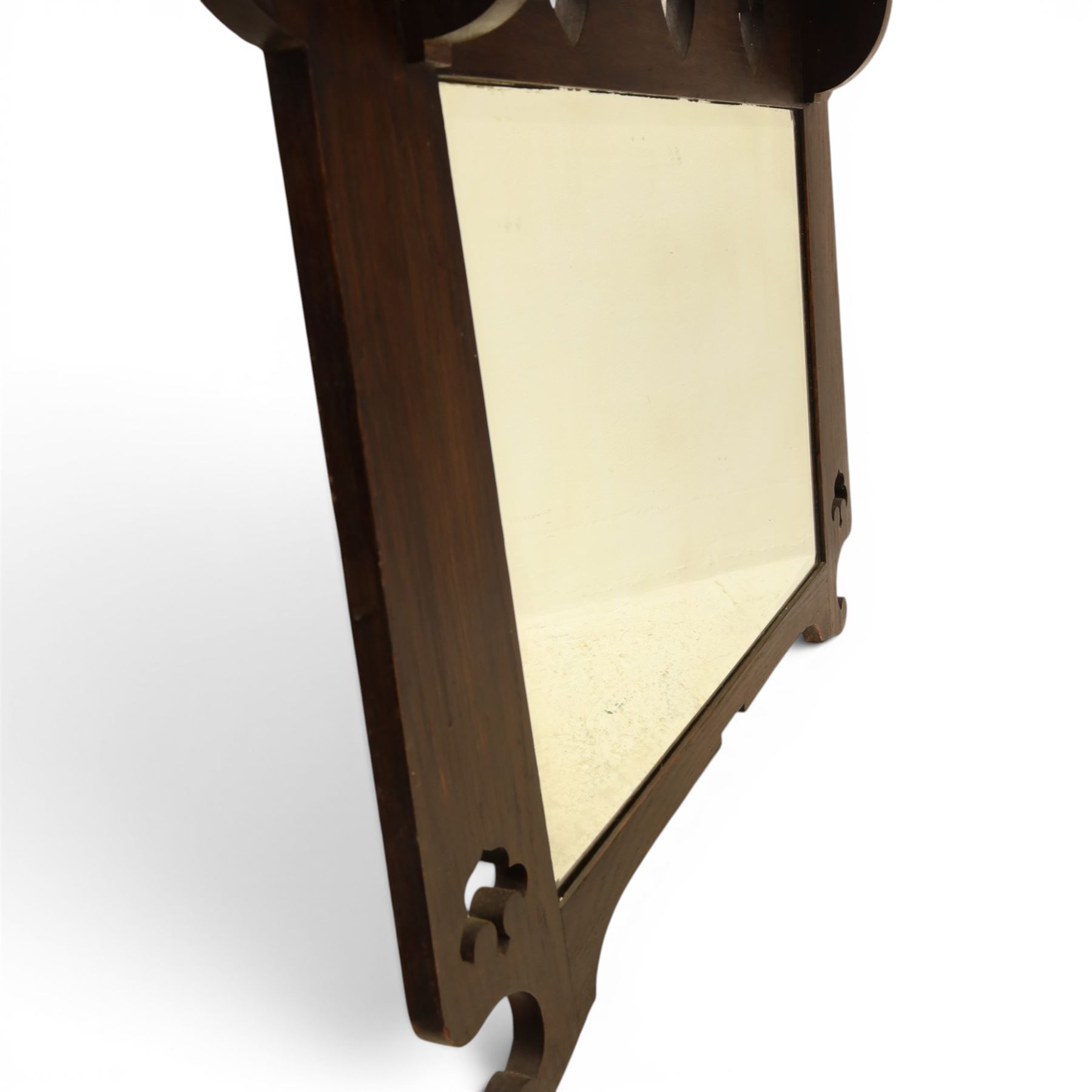 Arts and Crafts oak wall mirror, rectangular mirror plate within shaped frame, raised shelf with shaped back and pierced heart detail, bracket supports and shaped lower rail