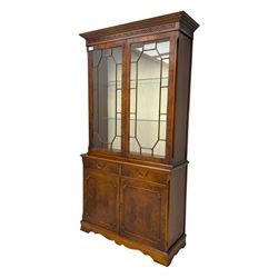 Ian Smith Furniture - Georgian design walnut bookcase on cupboard, projecting cornice above a pierced geometric frieze, featuring two astragal-glazed doors enclosing two adjustable shelves, the base with two drawers above a double cupboard, on a shaped plinth base