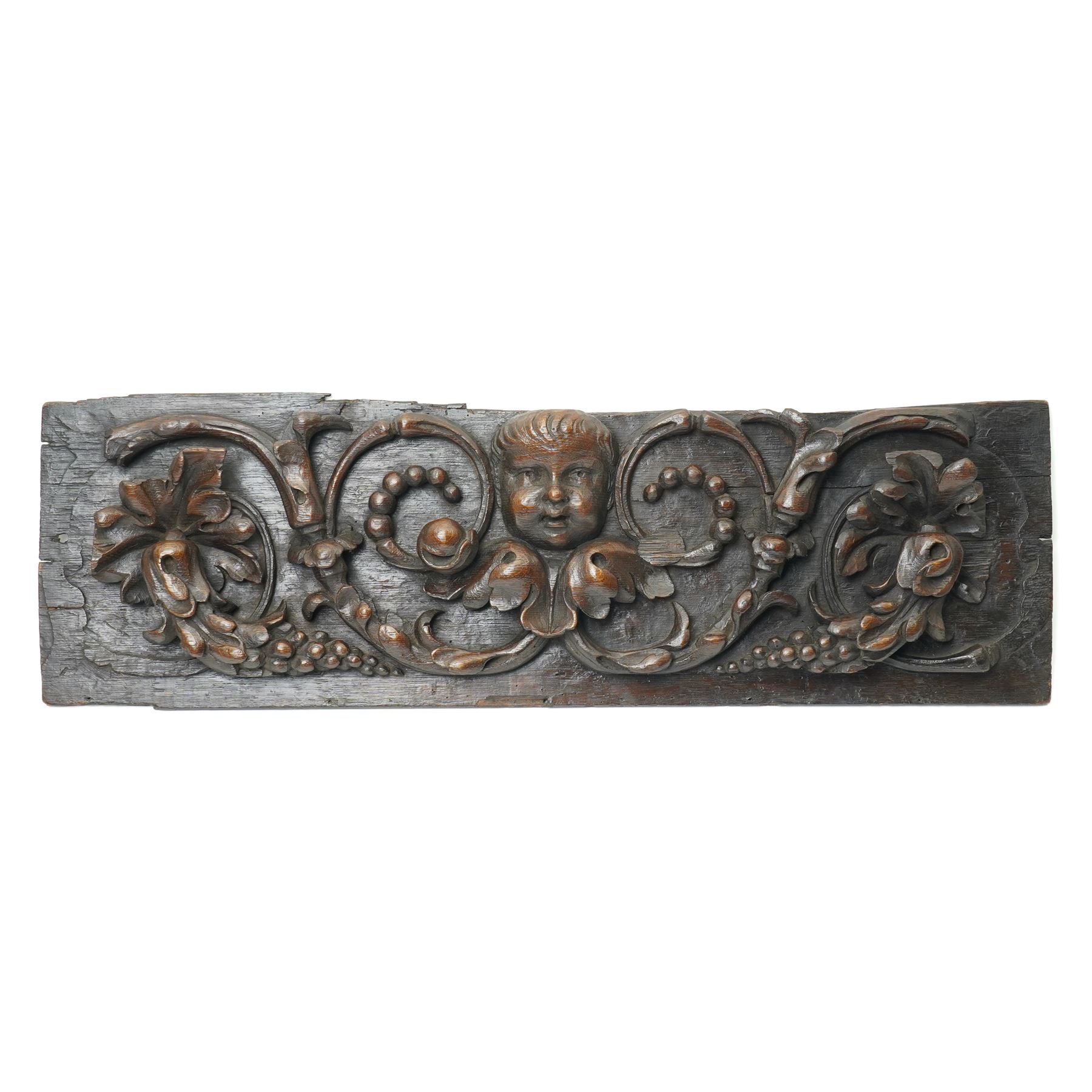 18th century oak panel carved with a cherubs head in high relief among fruit and foliage, W75cm