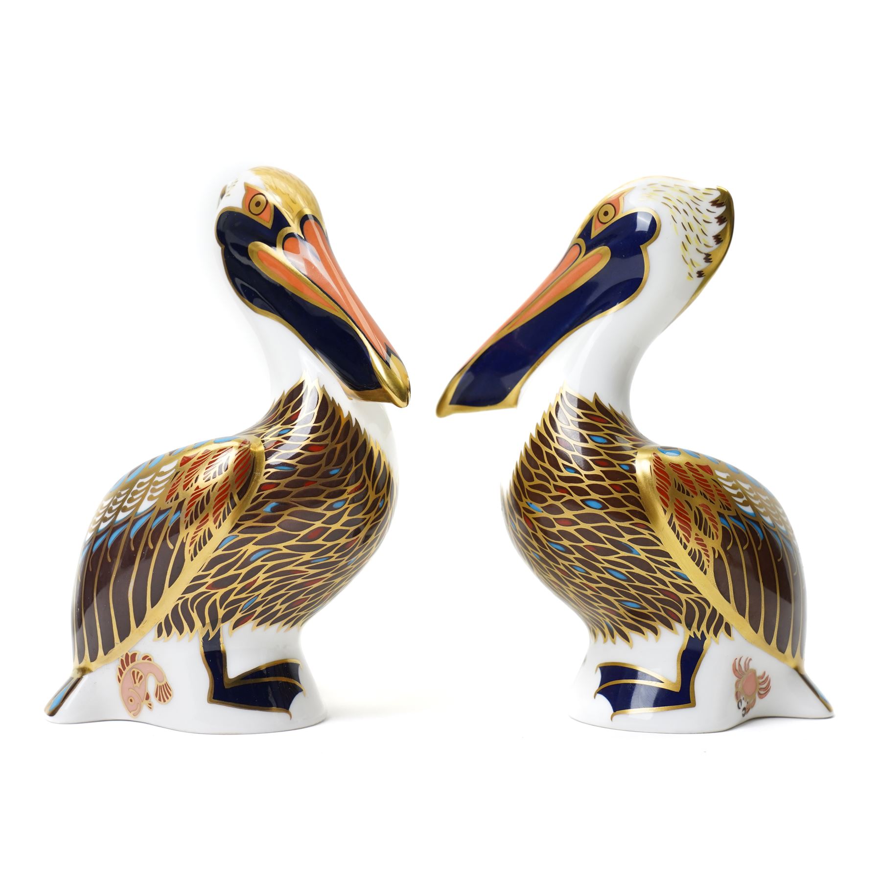 Four Royal Crown Derby paperweights, comprising Meerkat with gold stopper, two Brown Pelicans with gold stoppers, and one Cheetah Cub with gold stopper (4)