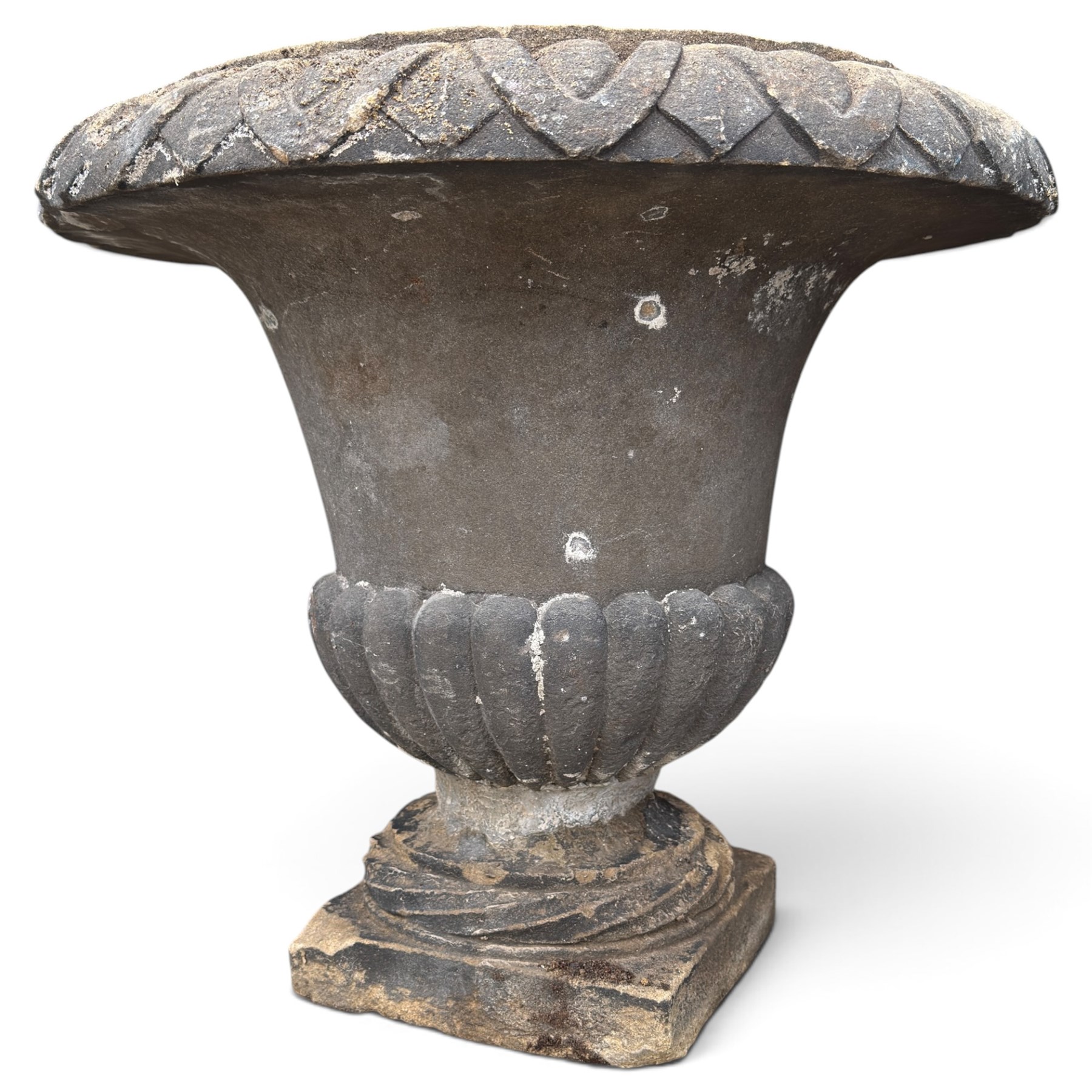 Set of three 19th century weathered carved sandstone garden urns of Neoclassical campana form, the broad everted rim carved with pointed egg-and-dart motifs, above a plain waisted bowl with gadrooned underbelly, on moulded rope-twist socle and square plinth base