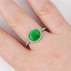 Platinum jadeite and diamond cluster ring, single oval cabochon cut jadeite of 2.20 carat, surrounded by round brilliant cut diamonds and diamond set shoulders, stamped Plat