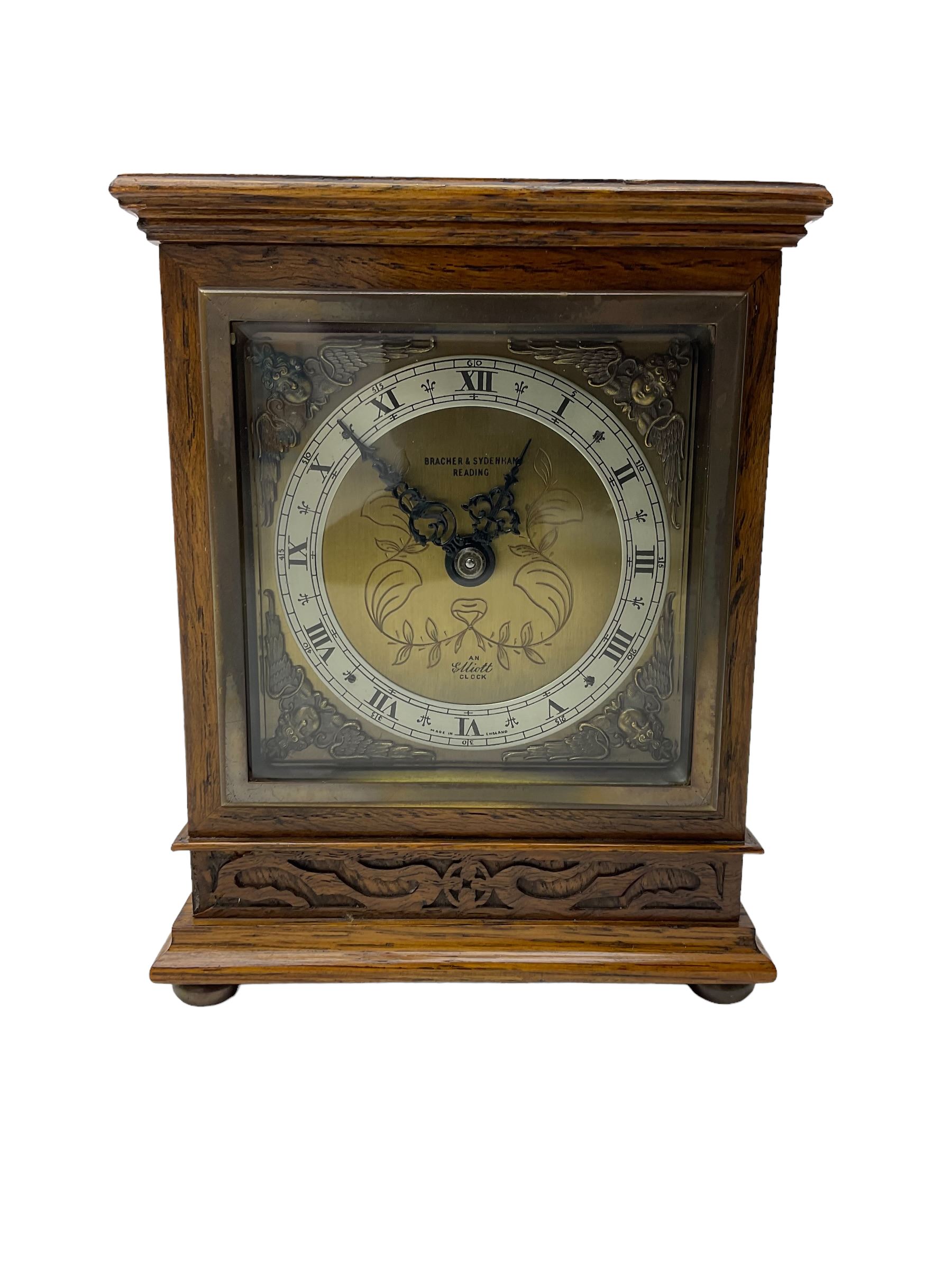 Elliot - oak cased 1950’s 8-day timepiece mantle clock, with a balance wheel movement wound and set from the rear, flat topped case with a carved panel raised on bun feet, square brass dial, silver chapter ring, spandrels and  decoratively engraved dial centre inscribed “Bracher & Sydenham, Reading”