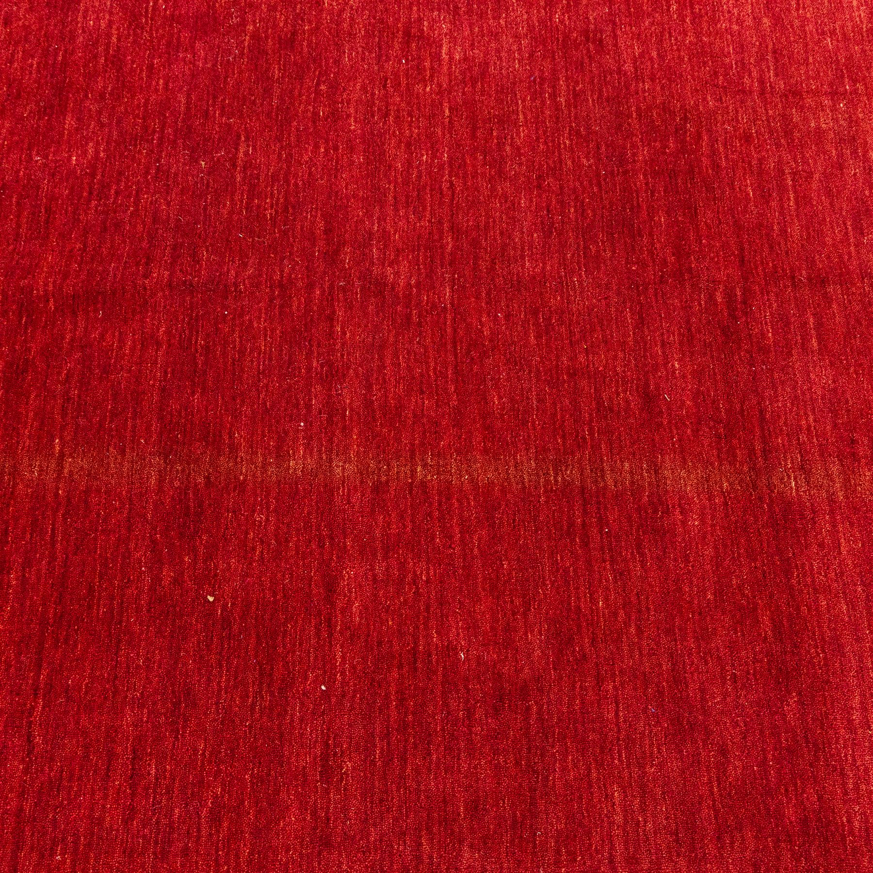 Two contemporary Moroccan Berber hand-woven rugs, deep madder red field of plain design, 199x153cm, other with deep madder red field with a simple lattice of ivory lines forming panels with some tonal variation, 190x146cm 