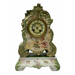 An early 20th century French porcelain clock with rococo scrolling in a cartouche form with gilt highlights, adorned with applied transfer images of cupid, cherubs and a sleeping maiden, matching porcelain plinth, eight-day two train Parisian movement striking the hours and half-hours on a bell, countwheel movement with a recoil escapement, enamel dial with a recessed centre, gilt winding collets, upright Arabic numerals and minute markers, steel fleur de Lis hands, cast brass bezel with bevelled glass.
With pendulum and Key.   
