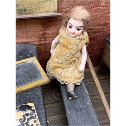 Late Victorian wooden school room setting with bisque head teacher and six German all bisque pupils each seated at a combined desk and chair with slate board, in a classroom furnished with chest of drawers, fire-surround, lectern, wall map, pictures, miniature books, school bell, chalk board on easel, wall clock etc, L70cm H28cm D28cm