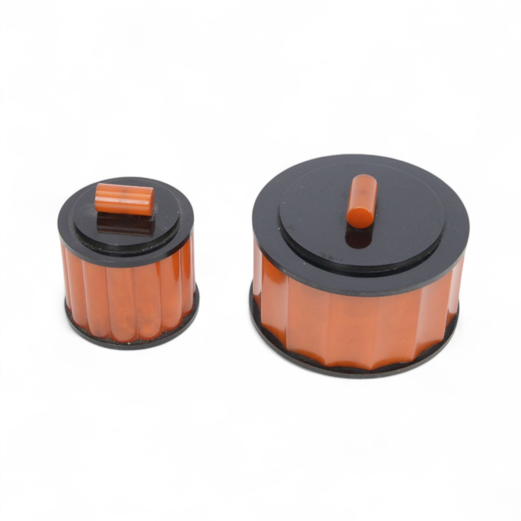 Art Deco phenolic Bakelite dressing table set, comprising three circular jars with lids and a pin dish, all upon a rectangular tray with black handles tray 30x19cm 