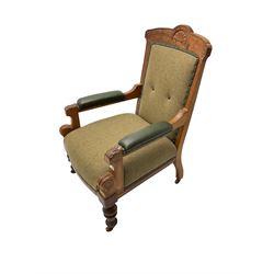 Late 19th century walnut framed armchair, cresting rail carved with cartouche and Greek key design, seat and back upholstered in green tweed fabric, arms upholstered in green leather with studwork, arm terminals carved with foliate and scrolled decoration, raised on turned supports with brass and ceramic castors