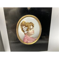 Continental printed and painted portrait miniature upon porcelain, of oval form depicting head and shoulder portrait of a young woman in pink dress with white flowers in her hair in gilt metal mount and rectangular ebonised frame with acorn and oak leaf mounted suspension ring, miniature H8cm W6cm, together with a further painted portrait miniature upon ivory, depicting a head and shoulder portrait of a gentleman, in similar ebonised frame, miniature H7cm W5.5cm, (2)