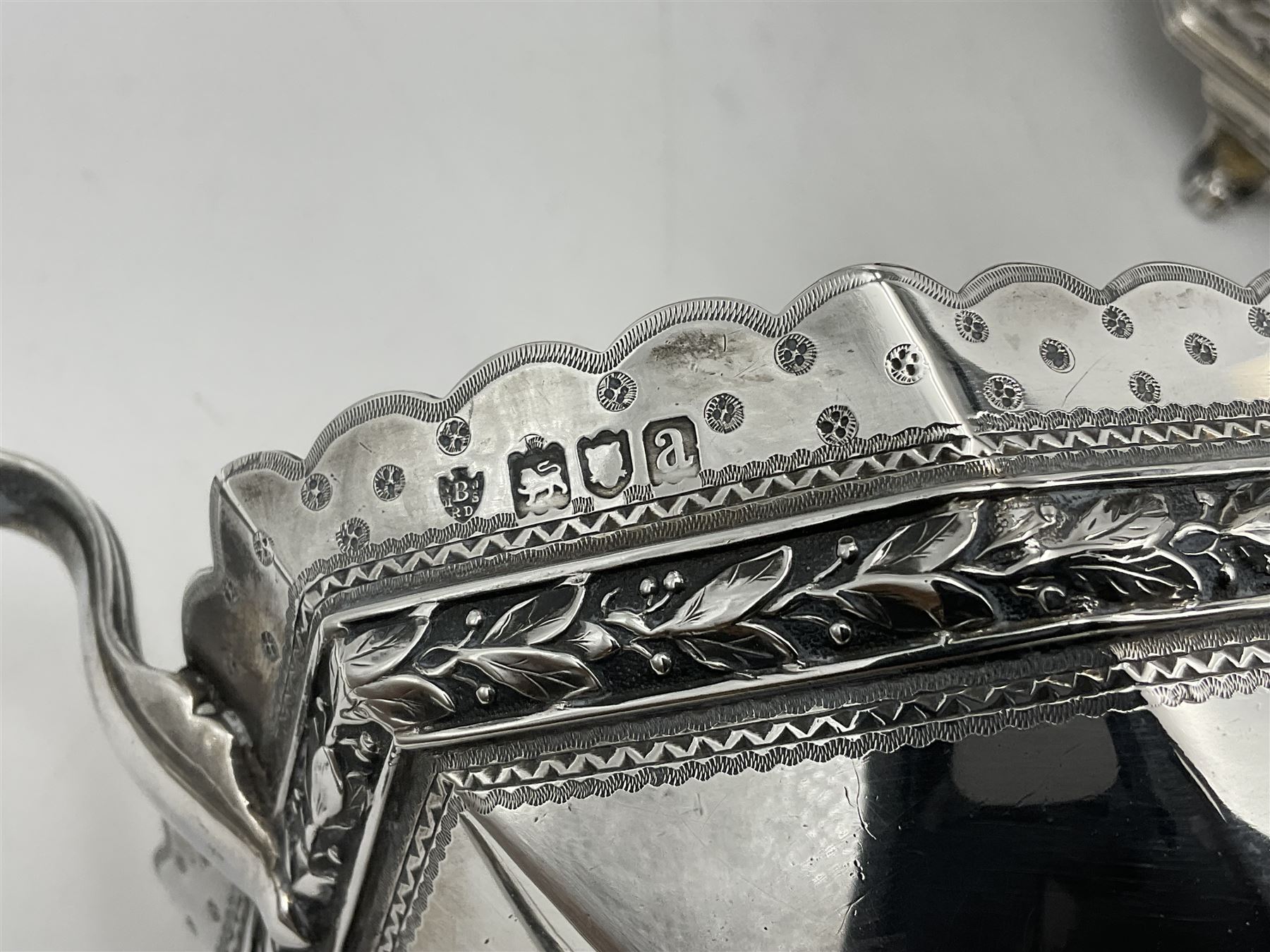 Victorian silver four piece tea service, comprising teapot, teapot stand, twin handled open sucrier and milk jug, each of octagonal form with foliate bud border and engraved decoration including crest to canted panels, and vacant panels, the teapot with ivory finial to the hinged cover and later wooden handle, hallmarked Edward Barnard & Sons Ltd, London1896, teapot including finial H15cm, milk jug including handle H16cm, teapot stand W11.5cm

This item has been registered for sale under Section 10 of the APHA Ivory Act