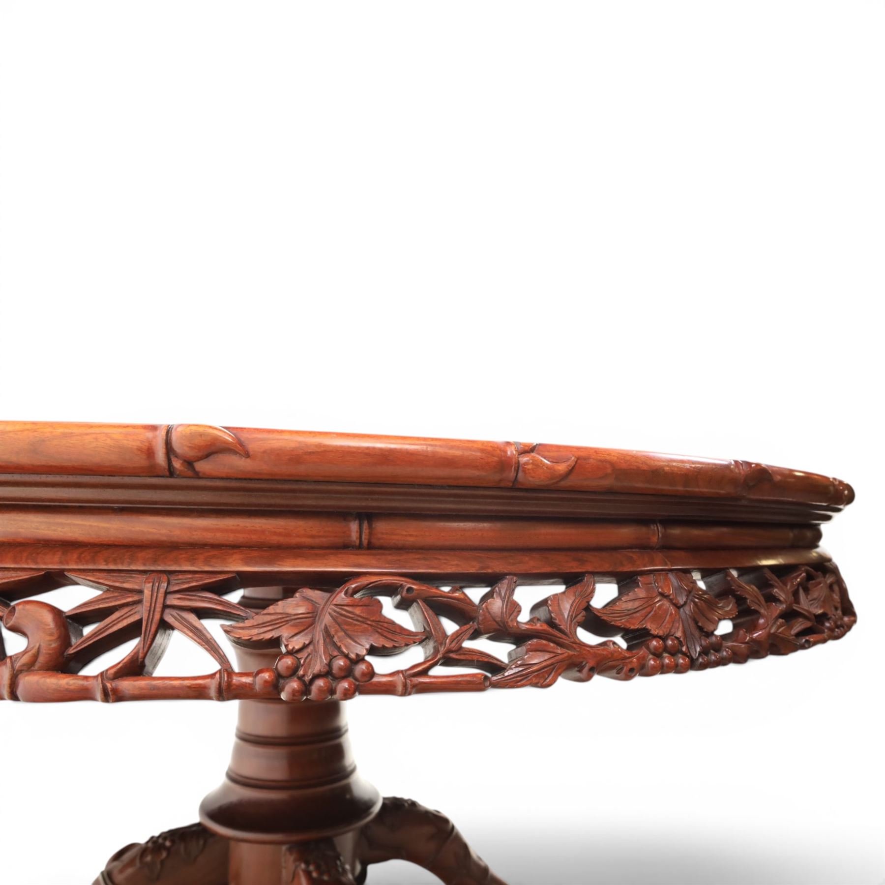 20th century Chinese ornately hardwood dining table and chairs, circular table with 'Lazy Susan' top with pierced carved frieze, raised on a quadriform base with carved foliate detail, the chairs en suite with carved pierced detailing  