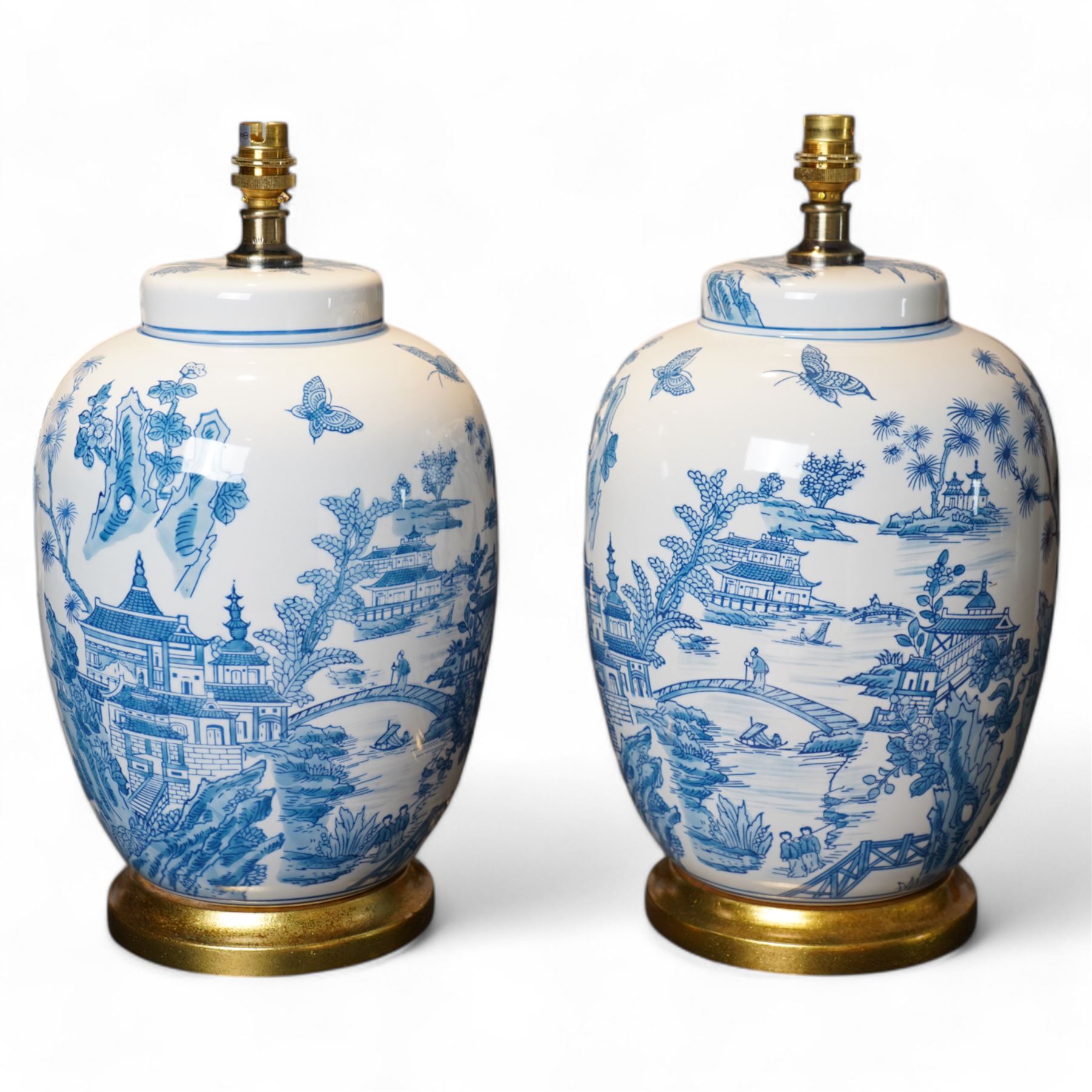 Pair of lamps of baluster form, decorated with a Japanese landscape on a white ground raised upon a gilt footed base, H60cm including shades 