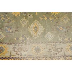Lage Turkish Oushak green ground carpet, the field decorated with large stylised plant motifs and geometric design, the sage green guard band with further repeating foliate motifs