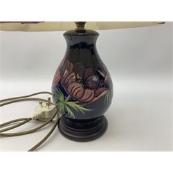 Moorcroft table lamp, of baluster form, decorated in Anemone pattern upon a dark blue ground, with accompanying cream shade of lobed form, with piped detail, H45cm