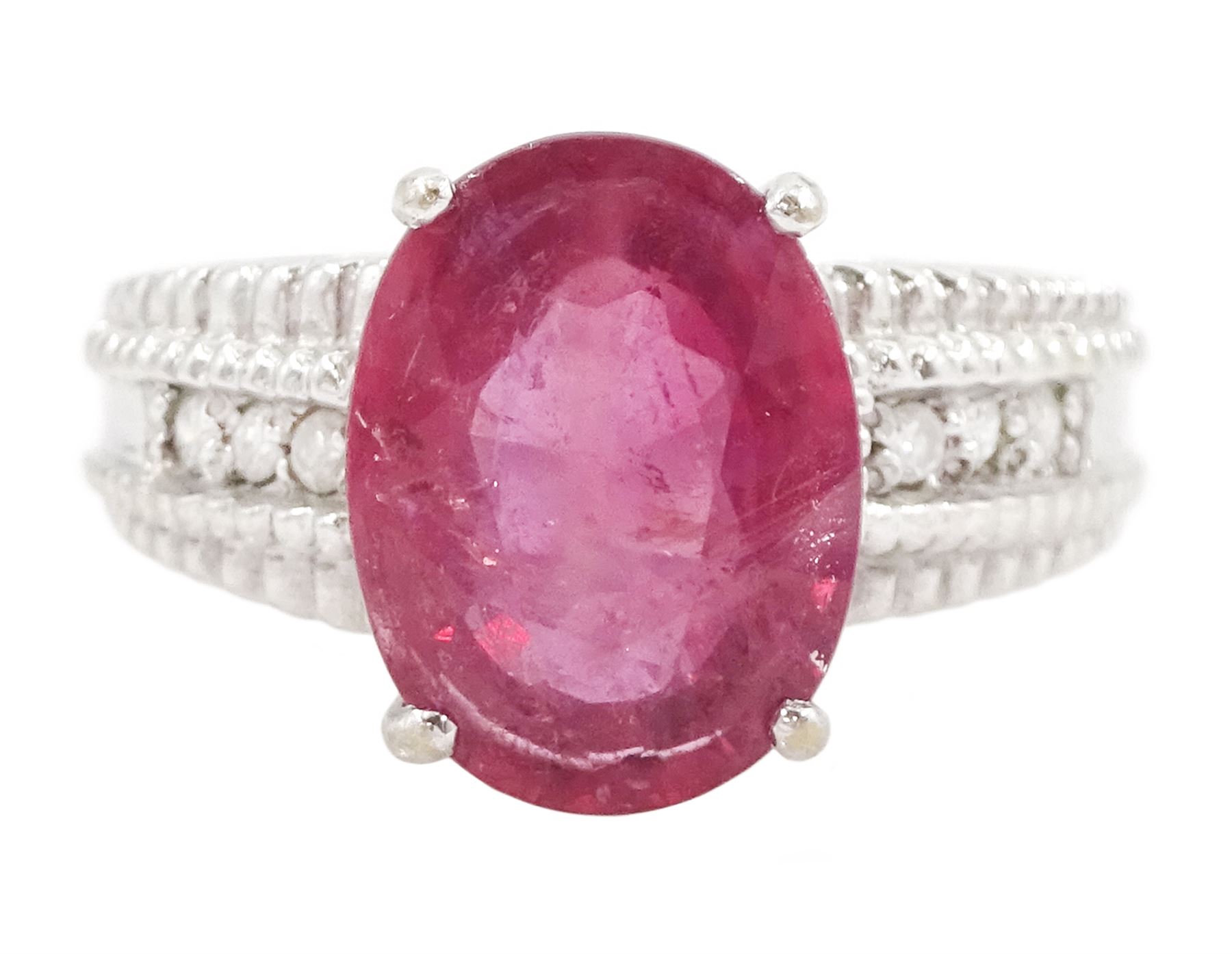 18ct white gold ruby and diamond ring, single oval cut ruby of approx 5.05 carat, with three round brilliant cut diamonds to each shoulder, Birmingham 2006