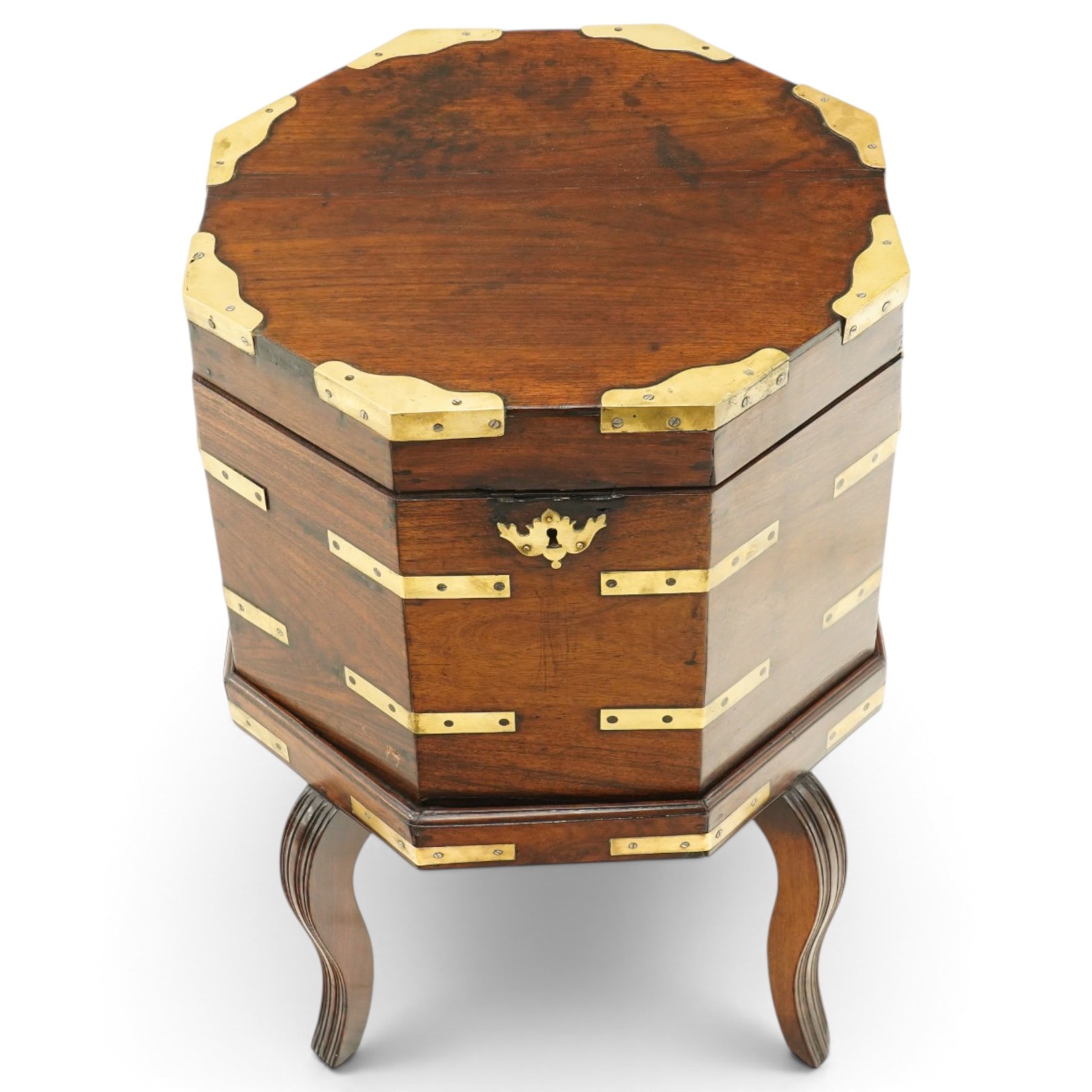 Late 18th century Anglo-Indian padouk and brass-bound octagonal cellarette or wine cooler, the hinged lid enclosing a vacant interior, the panelled body with applied brass strapwork, pierced escutcheon and side carrying handles, raised on a separate stand terminating to four fluted and reeded cabriole supports