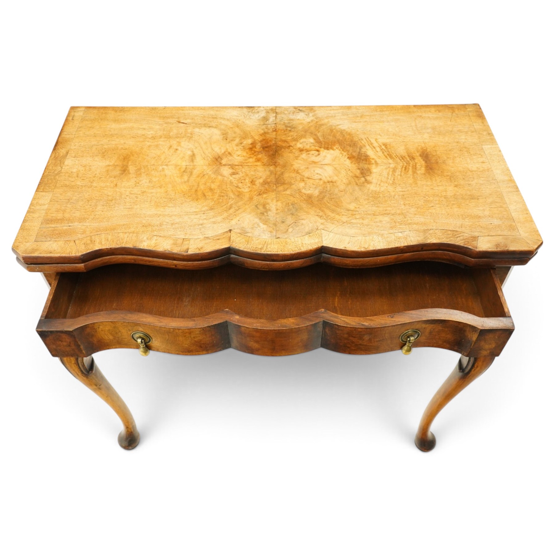 Quality early 20th century Queen Anne design walnut card table, rectangular book-matched veneer fold-over and swivel top with scalloped edge enclosing baize-lined interior, fitted with shaped frieze drawer with brass pear-drop handles over shaped apron, raised on C-scroll carved cabriole supports with pad feet
