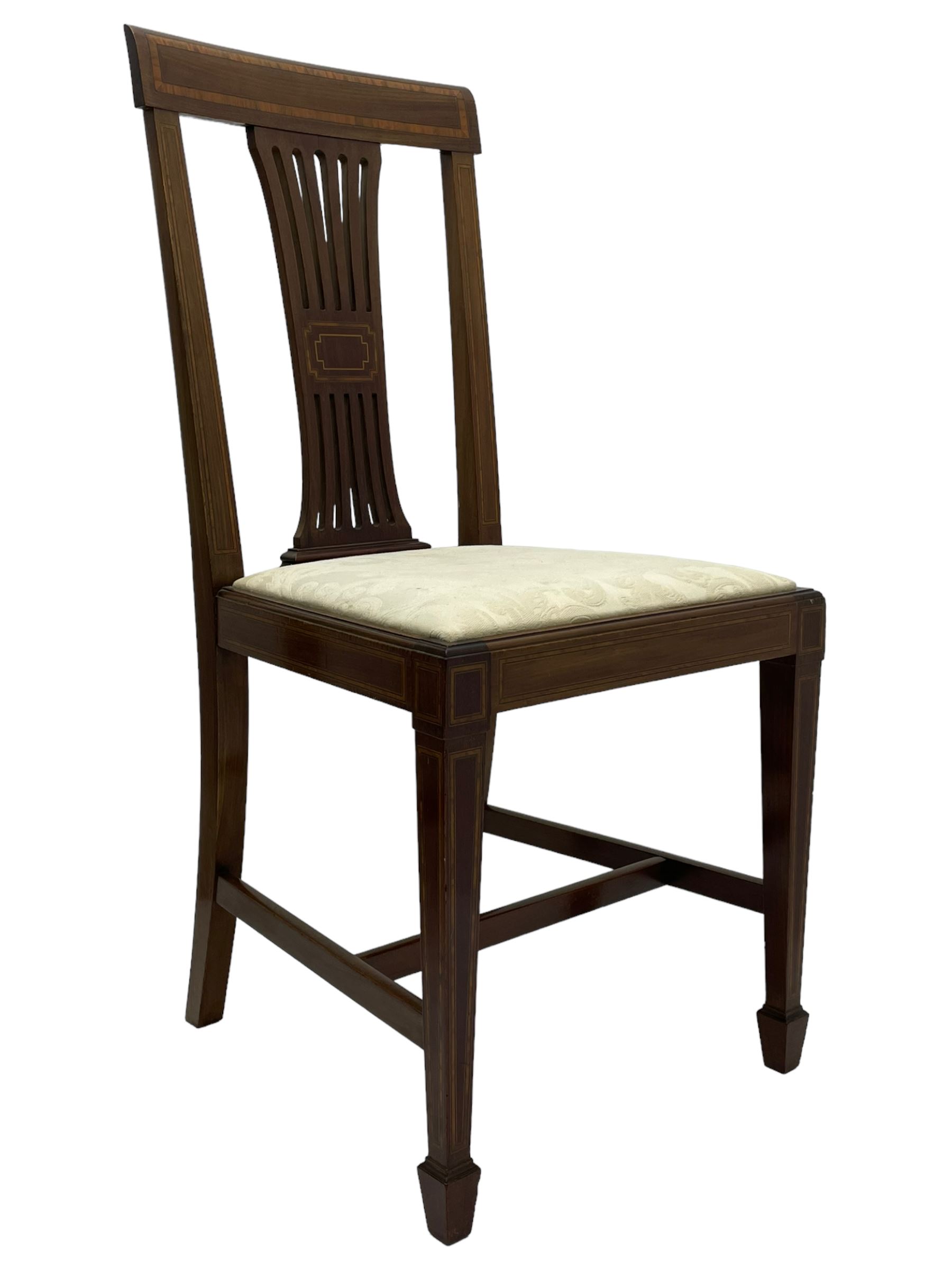 Set twelve (4+8) Edwardian inlaid mahogany dining chairs, cresting rail with satinwood banding, pierced splat backs with central inlay, drop-in seats upholstered in foliate patterned ivory fabric, raised on square tapering supports terminating in spade feet