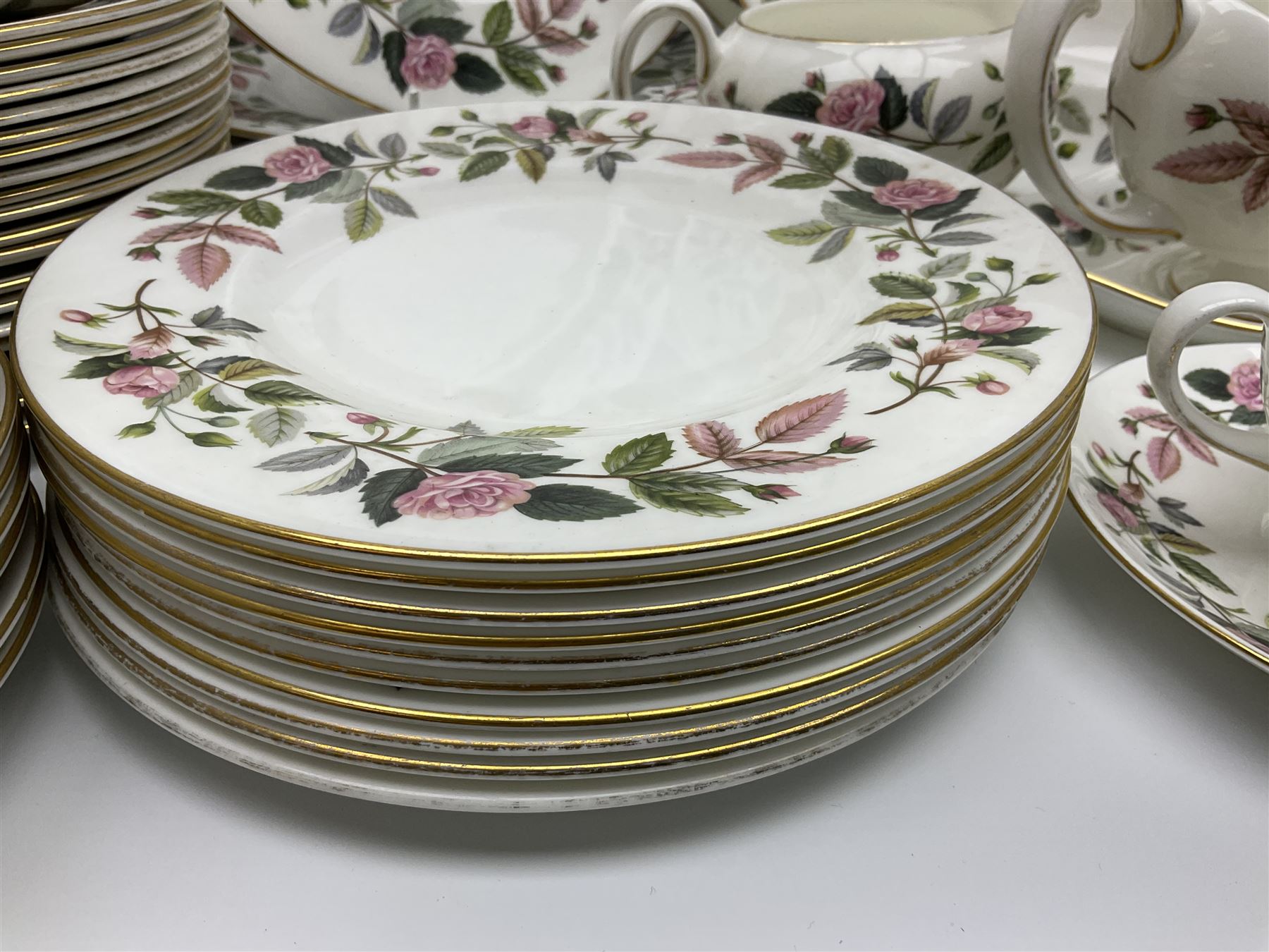 Wedgwood Hathaway Rose pattern tea and dinner wares, comprising twelve saucers, sixteen teacups, twenty tea plates, jug, sucrier, thirteen shallow bowls, sauce boat and saucer, two lidded tureens, larger jug, ten dinner plates, nine smaller plates and two large oval serving dishes