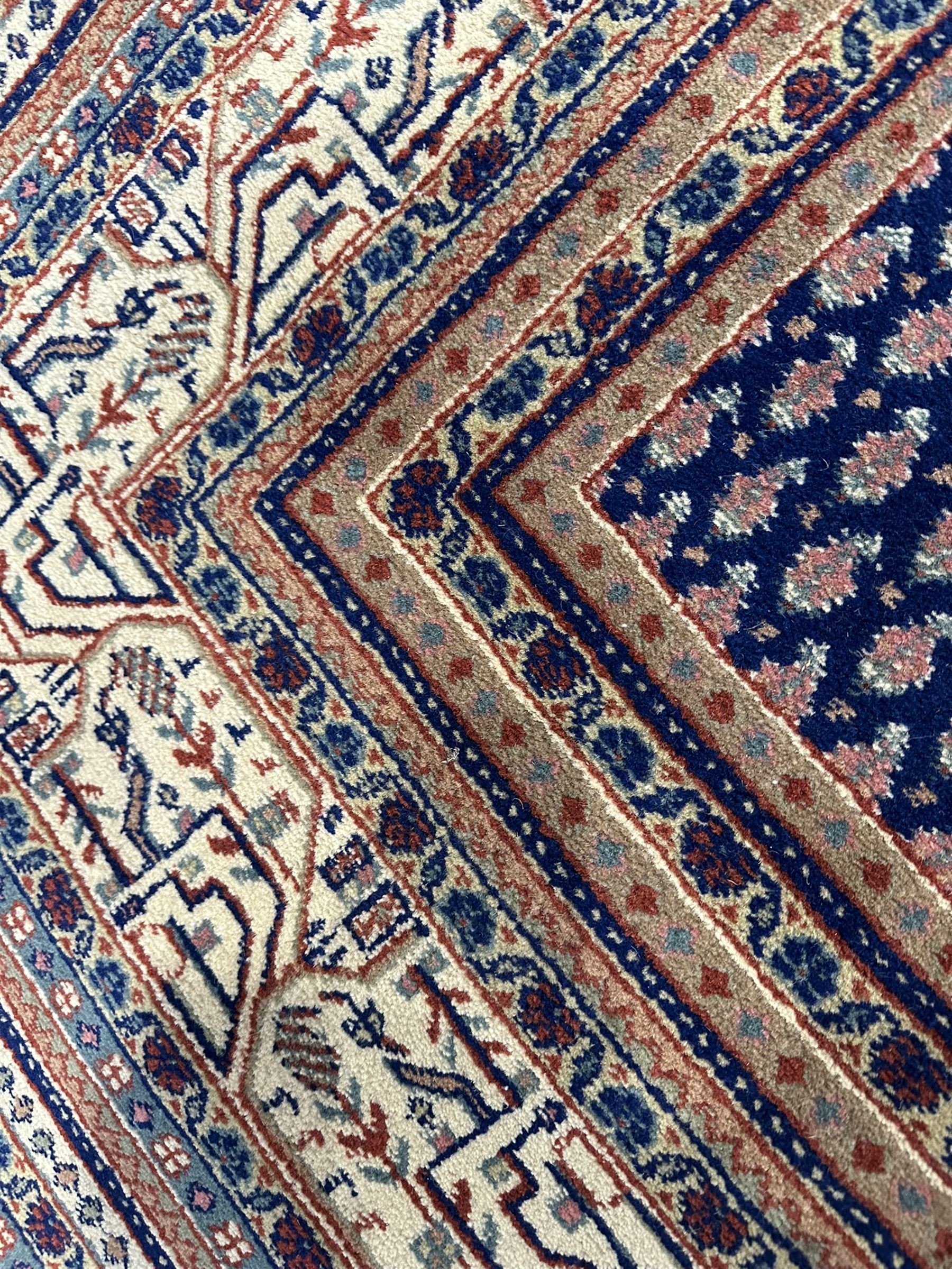 Large North-West Persian Arrak indigo ground carpet, the field decorated all-over with small Boteh motifs, multiple band border decorated with repeating geometric designs 