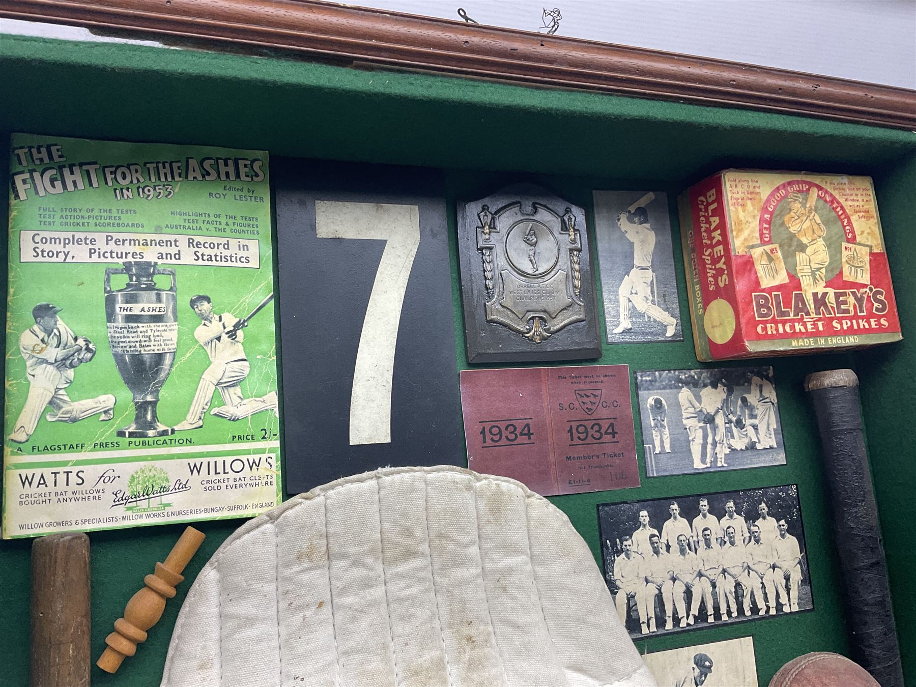 Four framed sporting memorabilia displays, the largest example containing 1930s cricket memorabilia, together with two fishing displays and a football display, each within wooden glazed frames, largest H105cm