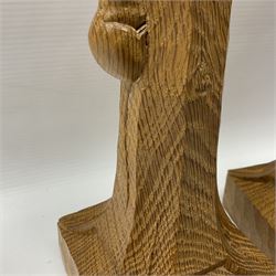 Mouseman - pair of tooled oak candlesticks, wrought iron sconce with drip tray over tapered octagonal column carved with mouse signature, terminating to stylised leaf carved square base, by the workshop of Robert Thompson, Kilburn
