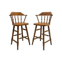 Pair of late 20th century beech bar stools, with curved top rail and turned spindle back, shaped seat over four turned legs united by multiple stretchers