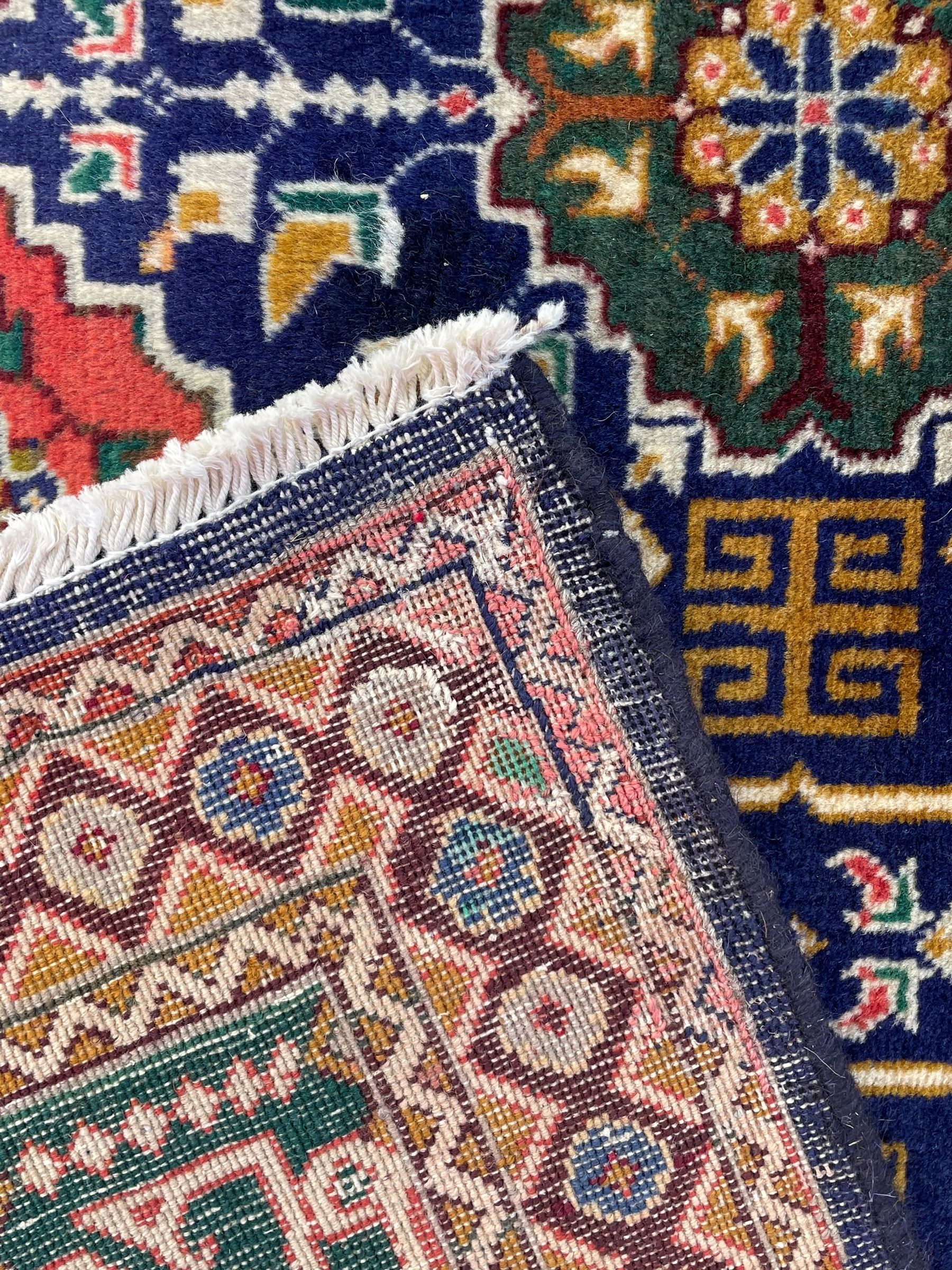 Persian Tabriz indigo ground rug, overall Quba design, decorated with repeating stylised plant motifs and interlaced with trailing leaf motifs, repeating border within geometric guard stripes