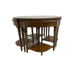 Yew wood circular coffee table with four nesting tables, inset leather and glass tops, on turned and fluted supports