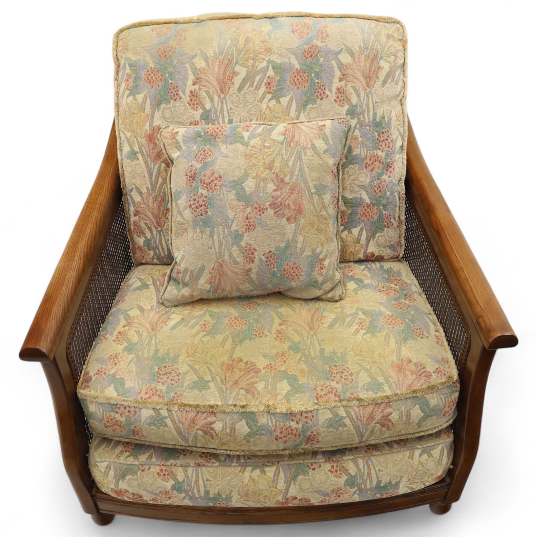 Ercol – bergère four piece suite, including armchair, two seat sofa, three seat sofa and footstool, all with removable floral upholstered cushions, the frames with side caning and rounded arm supports in stained beech

Three seat (H 87cm, D 89cm, W 196cm)
Two seat (H 87cm, D 89cm, W 137cm)
Armchair (H 87cm, D 89cm, W 87cm)
Footstool (H 28cm, D 55cm, W 55cm)