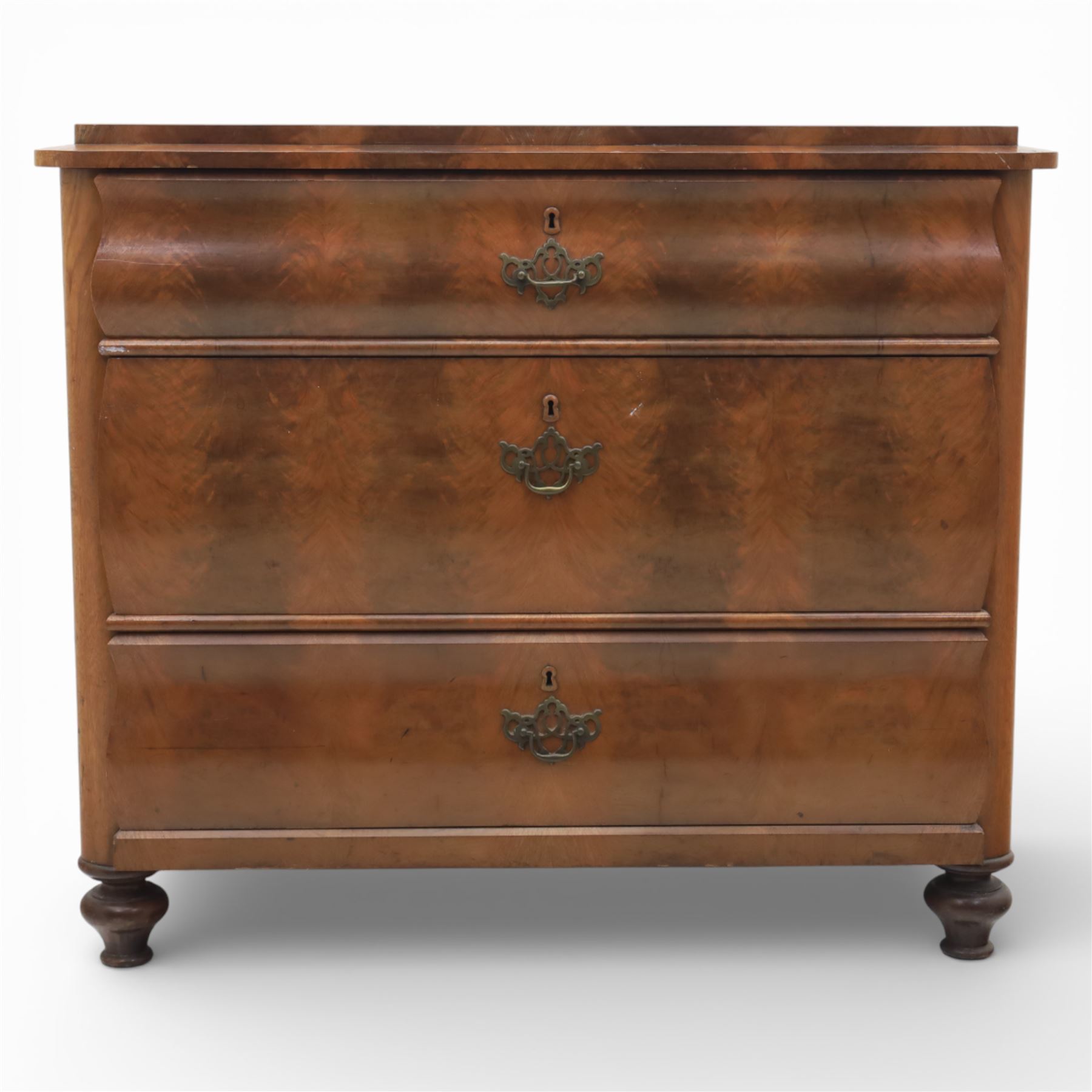 Late Victorian walnut and burr walnut chest of drawers, moulded top with rounded corners, finely figured burr walnut drawer fronts arranged as three long drawers, brass batwing handle plates, the lower section raised on turned bun feet