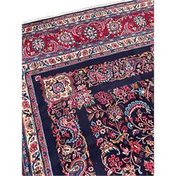 Persian Hamadan indigo ground carpet, the field decorated with central rectangle and outer band, overall floral pattern with cusped central medallion and surrounding leafy branches with palmettes, the border with scrolling branches decorated with further palmettes, within floral pattern guard stripes