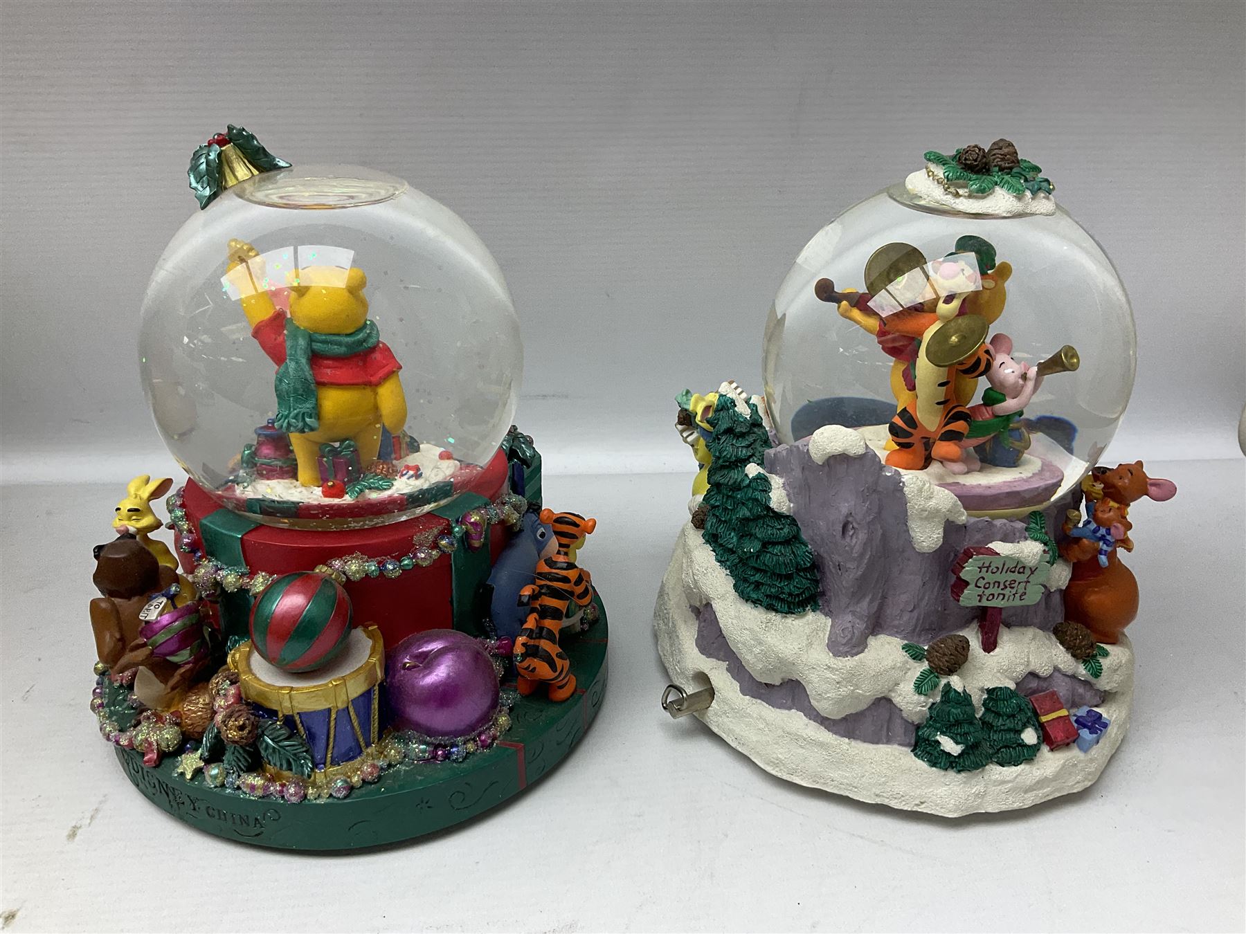 Six Disney Winnie the Pooh Christmas snow globes, comprising large Mr Christmas Holiday Snowfall, An Enchanted Christmas, It's A Small World Christmas 1994,  Tree Trimming, 1995 Christmas At Our House and Christmas Band Concert, together with Mr Christmas Holiday Go Round, all with boxes (7)